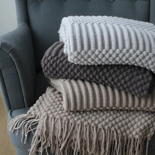 Small dark grey polyester nap blanket folded, showing its size of 127 cm by 170 cm.