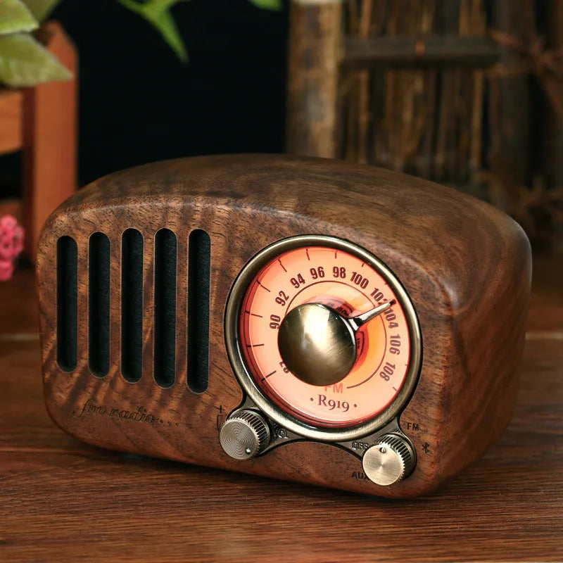 Compact retro wooden wireless Bluetooth speaker in cherry wood finish on a wooden table