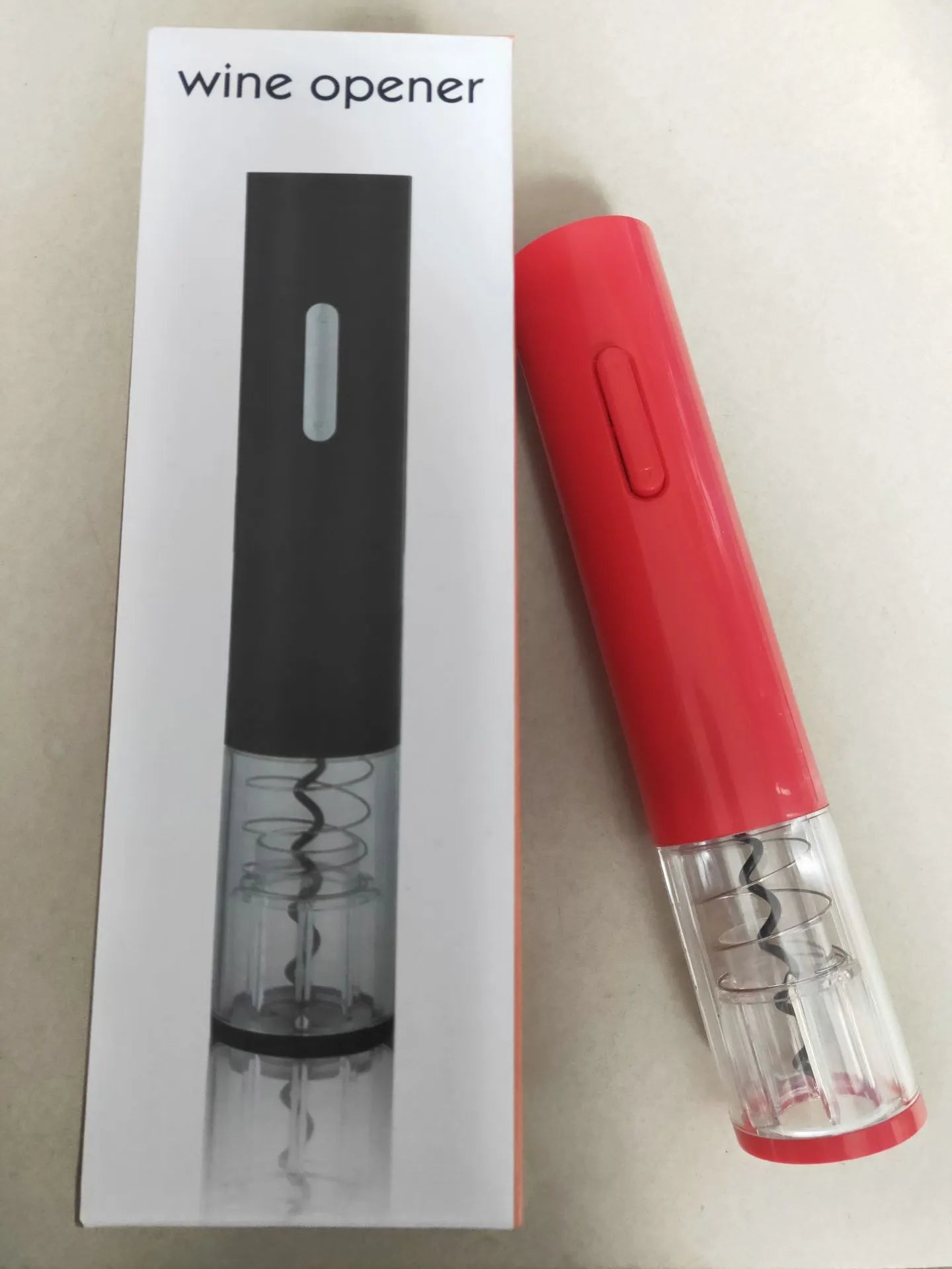 Black, red, and white electric wine bottle opener with foil cutter on a kitchen counter