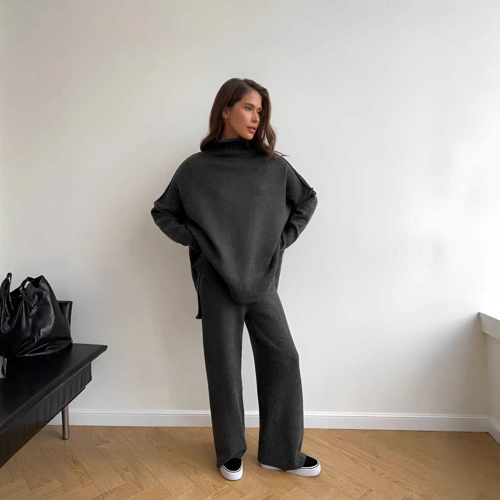 Women's acrylic suit set showing side-slit sweater top with matching trousers in solid colour
