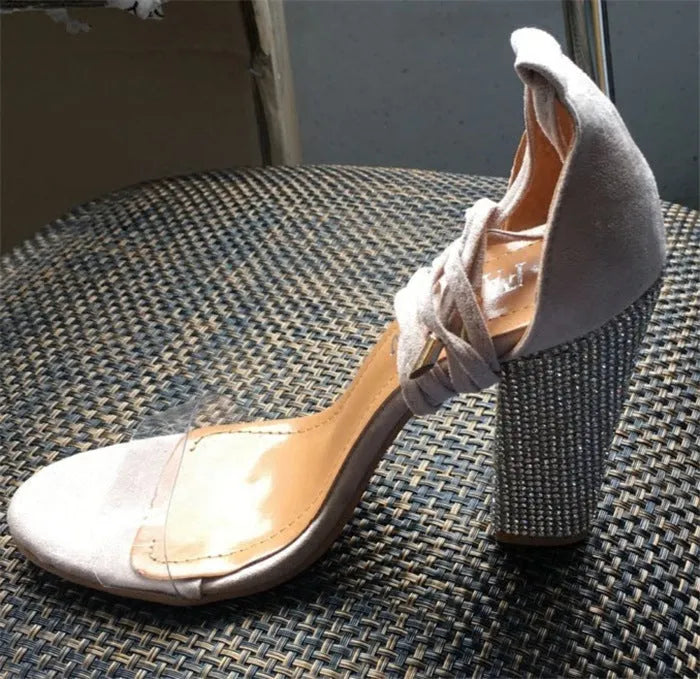 A pair of plastic high heels with a pointed toe, shown in black and gold colour options on a white background.