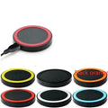 Square Qi wireless phone charging pad in multiple colours on a wooden surface.