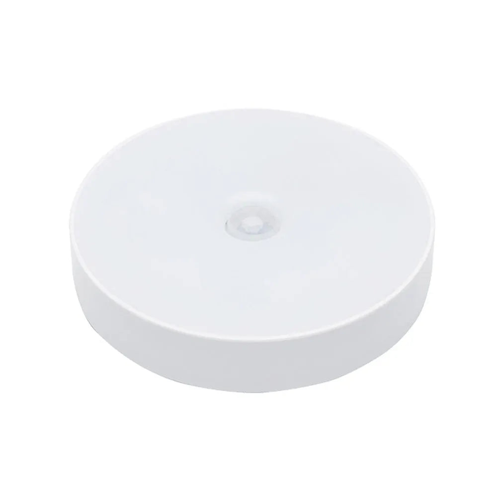 Compact round white LED motion sensor night light with USB charging cable and adhesive tape