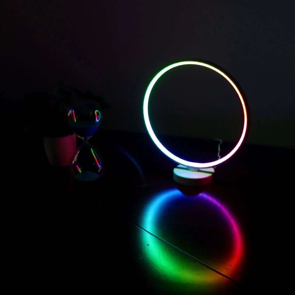 White Full Moon Table Lamp with remote control on a wooden surface, showing its spherical silicone and aluminium design.