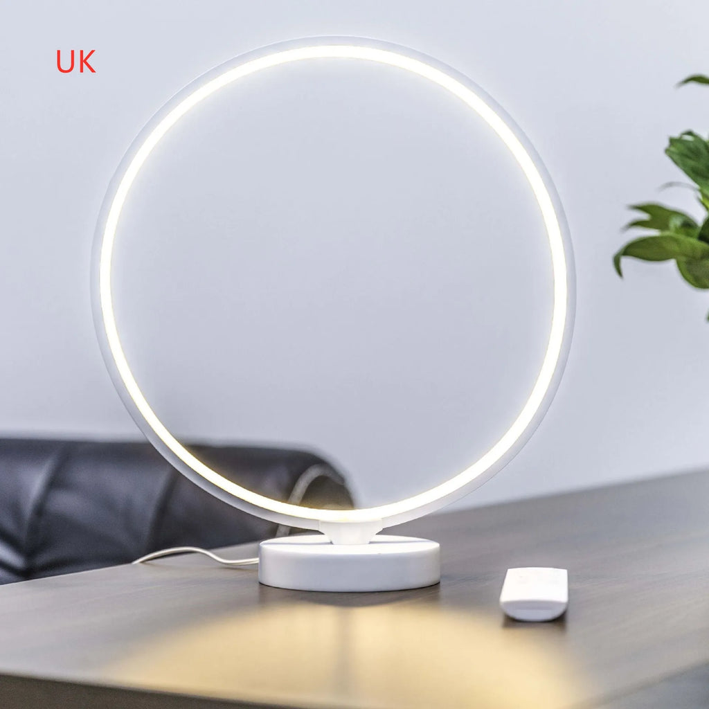 White Full Moon Table Lamp with remote control on a wooden surface, showing its spherical silicone and aluminium design.
