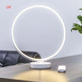 White Full Moon Table Lamp with remote control on a wooden surface, showing its spherical silicone and aluminium design.
