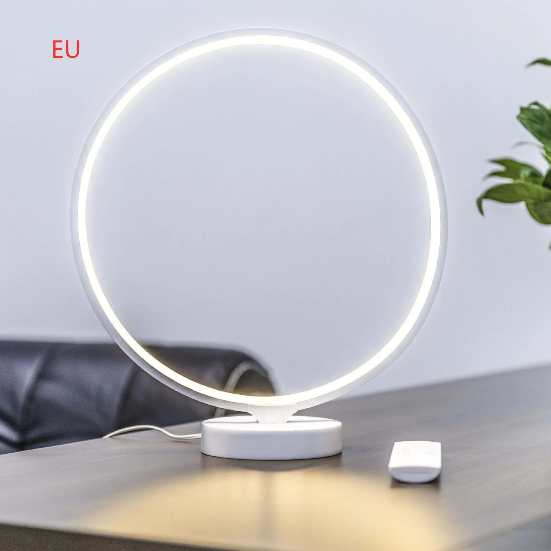 White Full Moon Table Lamp with remote control on a wooden surface, showing its spherical silicone and aluminium design.