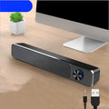 G18 black and white compact desktop computer speaker with Bluetooth on a wooden desk.