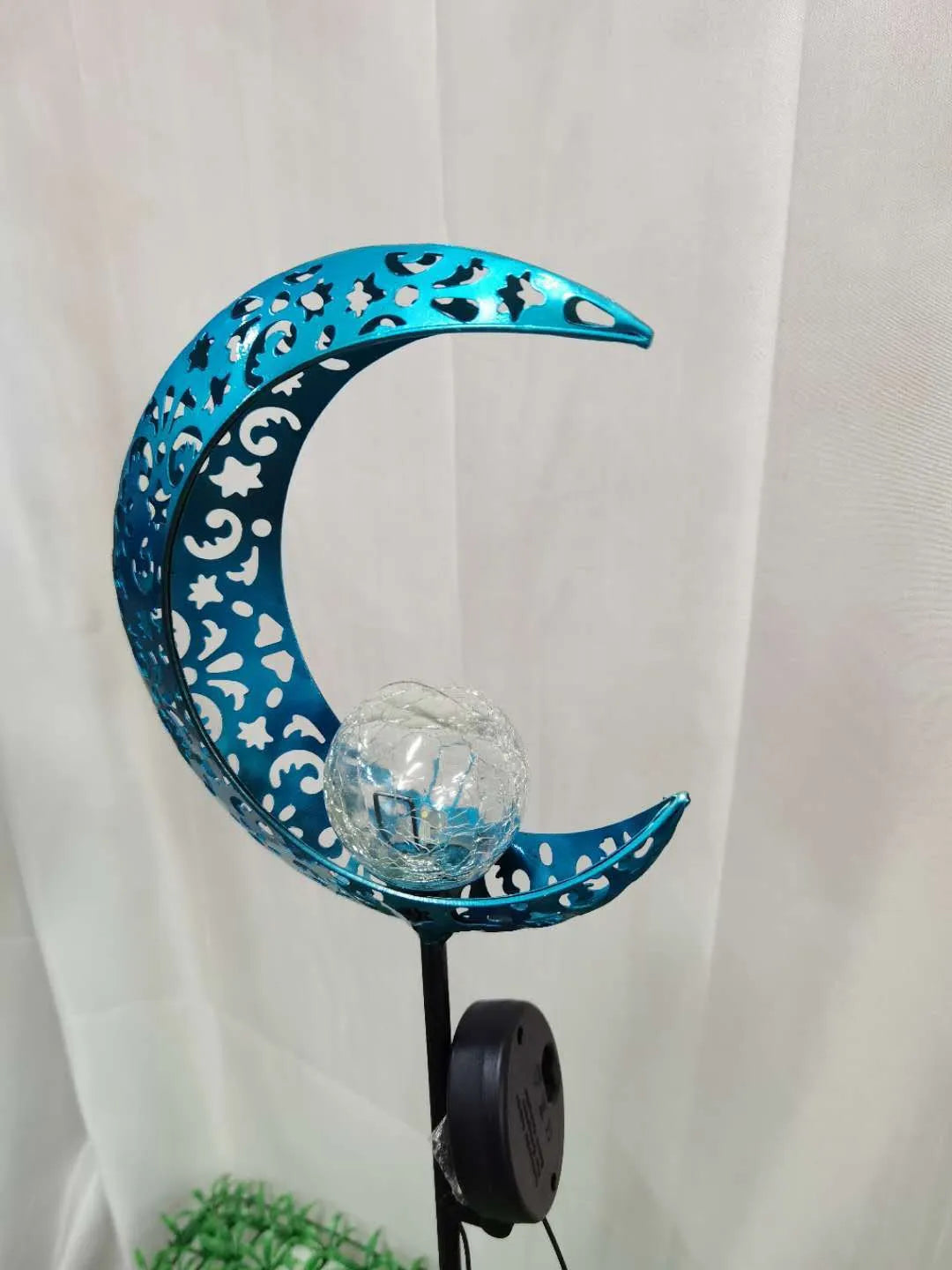 Blue moon-shaped solar garden light with wrought iron metal frame and crack glass ball.