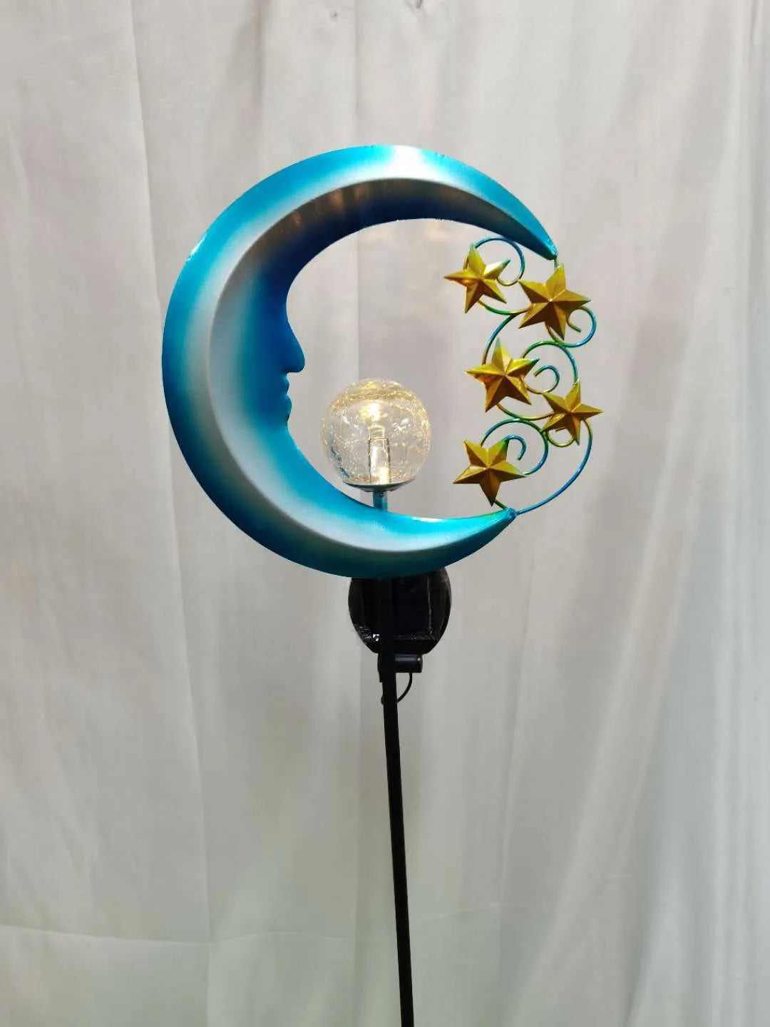 Blue moon-shaped solar garden light with wrought iron metal frame and crack glass ball.
