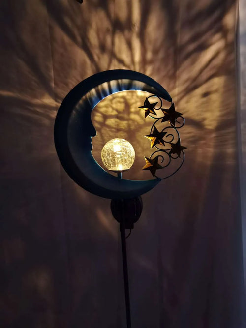 Blue moon-shaped solar garden light with wrought iron metal frame and crack glass ball.