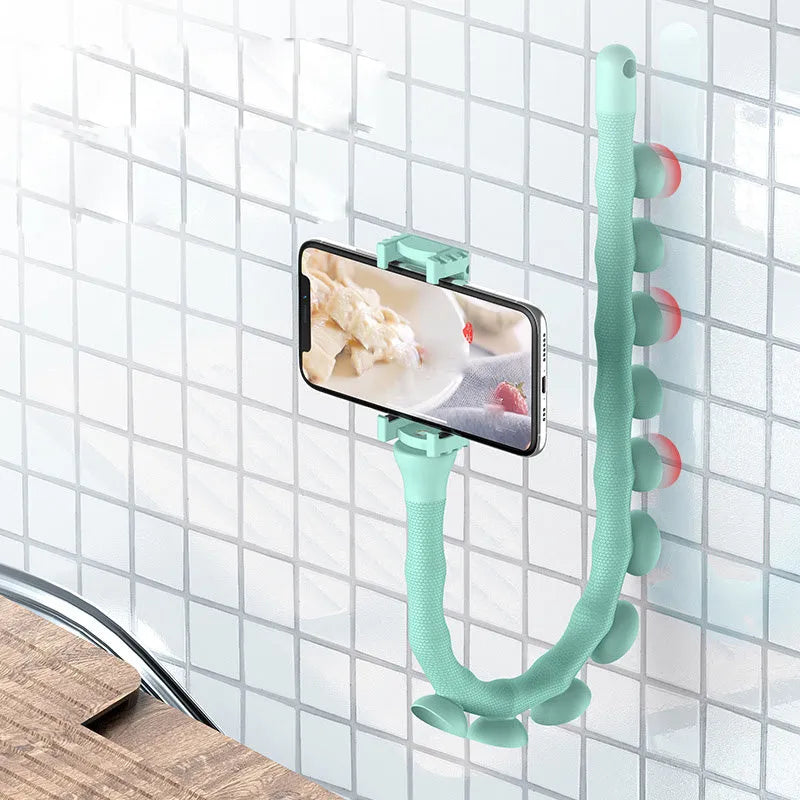 Flexible black suction cup phone holder bent into position on a desktop