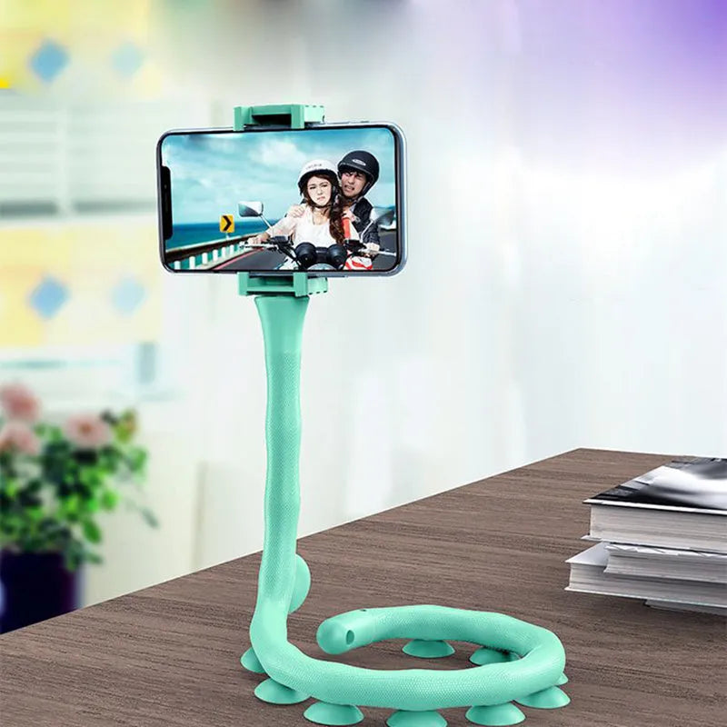 Flexible black suction cup phone holder bent into position on a desktop