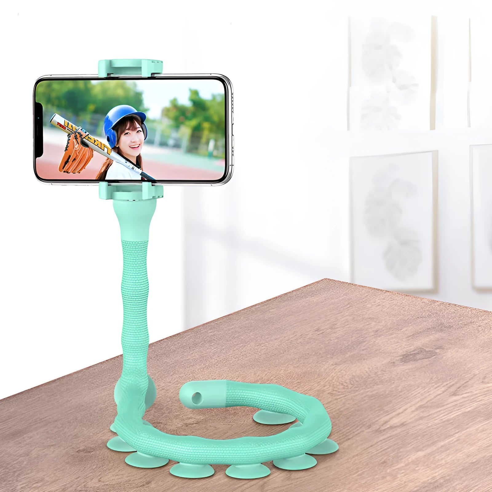 Flexible black suction cup phone holder bent into position on a desktop