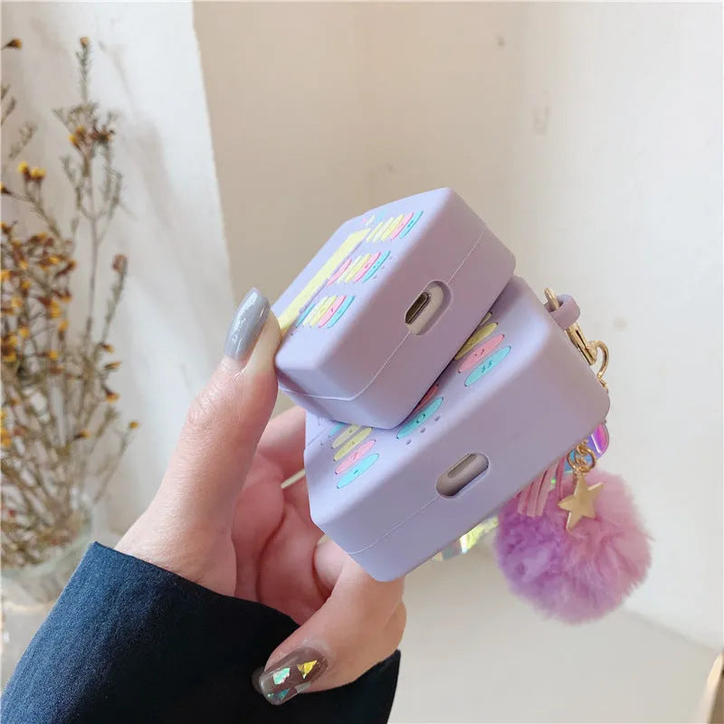 Purple silicone Apple AirPods case with clamshell design and attached fur ball pendant