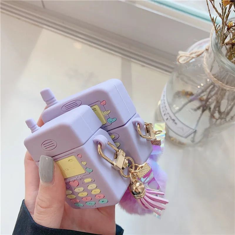 Purple silicone Apple AirPods case with clamshell design and attached fur ball pendant