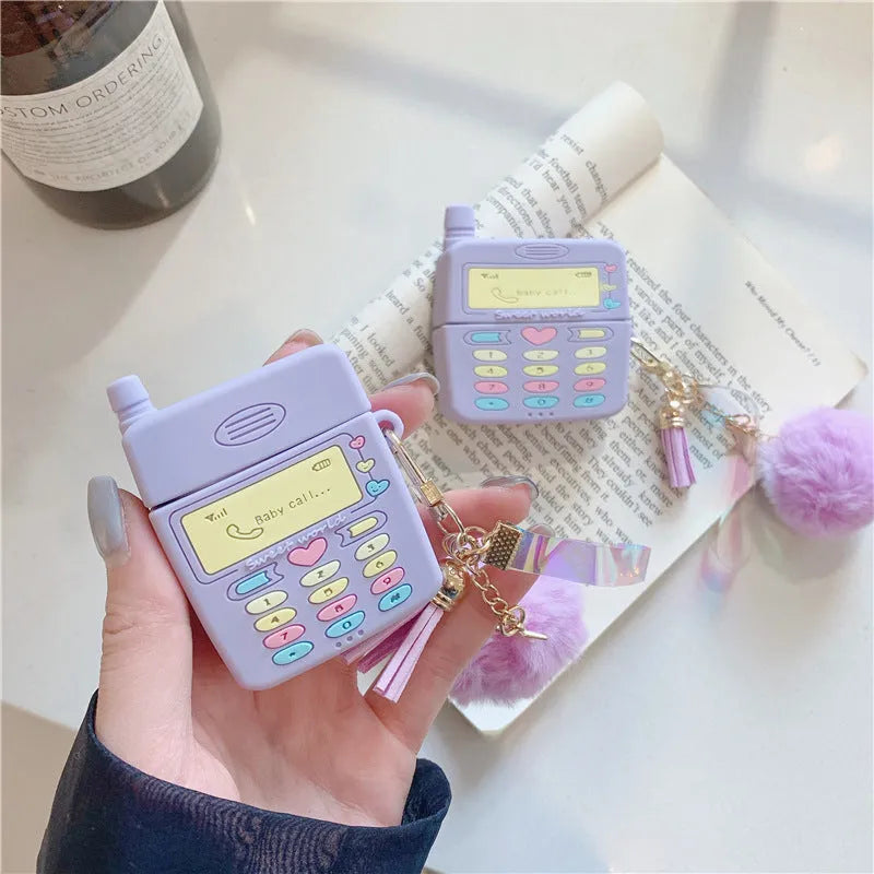 Purple silicone Apple AirPods case with clamshell design and attached fur ball pendant
