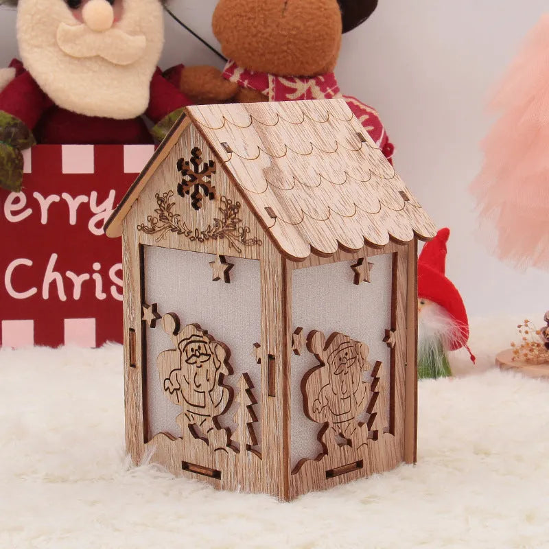 Three wooden Christmas decorations: small log bell and two wooden houses with Father Christmas and snowman designs