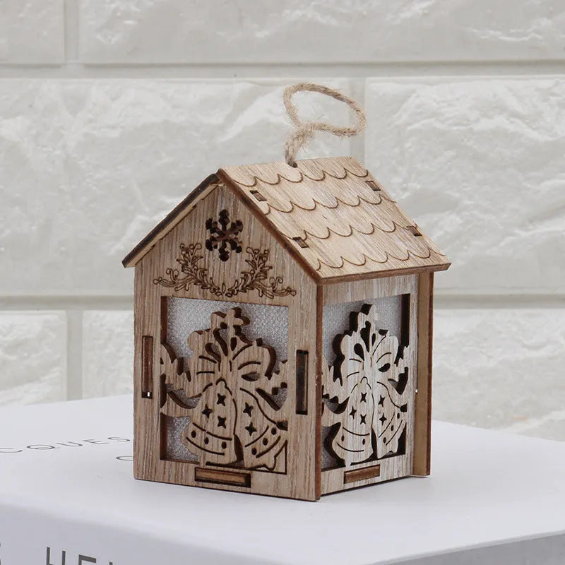 Three wooden Christmas decorations: small log bell and two wooden houses with Father Christmas and snowman designs