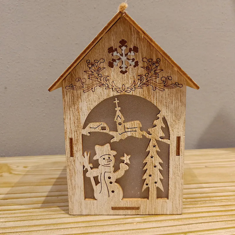 Three wooden Christmas decorations: small log bell and two wooden houses with Father Christmas and snowman designs