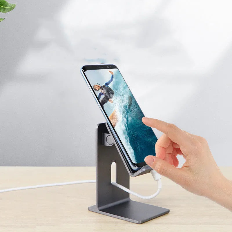 Dark space grey metal alloy universal mobile phone holder on a wooden desk