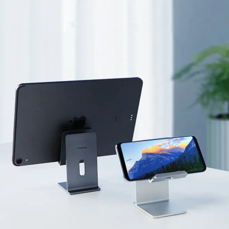 Dark space grey metal alloy universal mobile phone holder on a wooden desk
