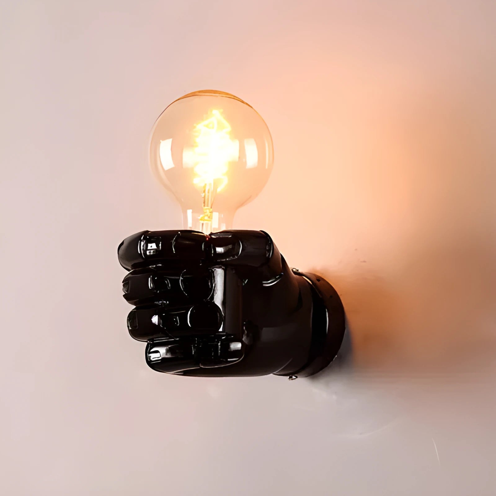 Decorative resin wall lamp sculpted as a clenched fist, available in black, white, and wood grain finishes.