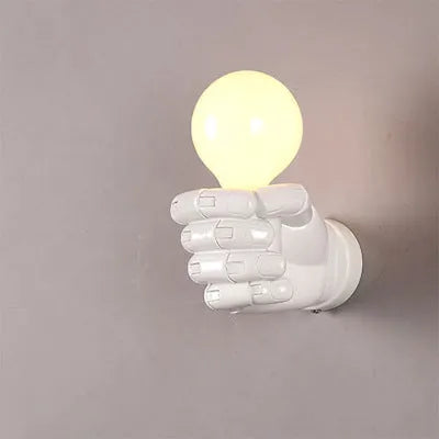 Decorative resin wall lamp sculpted as a clenched fist, available in black, white, and wood grain finishes.