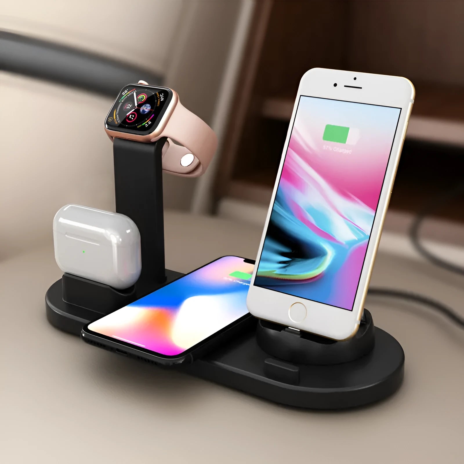 Black three-in-one wireless charging station holding an Apple Watch, AirPods case, and an iPhone on a desk.