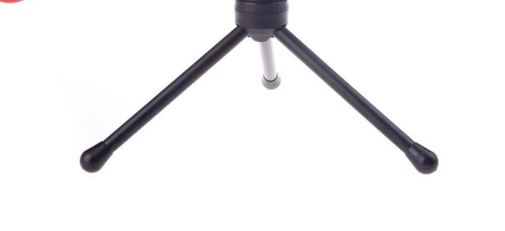 Black wired PC microphone with a long cable and a detached metal clip holder on a desk.