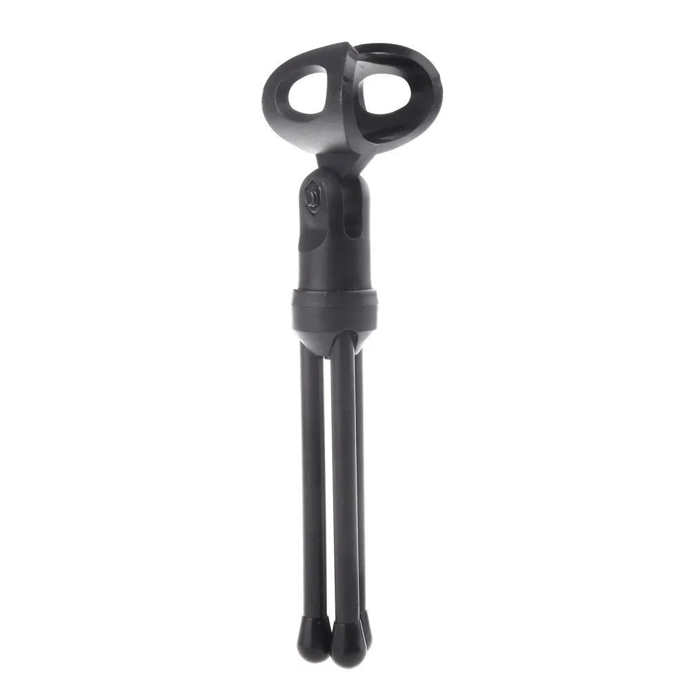 Black wired PC microphone with a long cable and a detached metal clip holder on a desk.