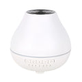 Round white Bluetooth humidifier and aroma diffuser with night light on a surface.