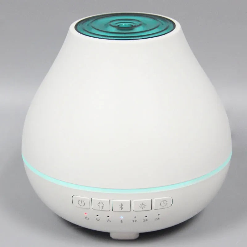 Round white Bluetooth humidifier and aroma diffuser with night light on a surface.