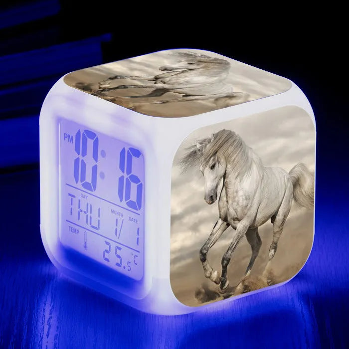 Small square cartoon-style LED alarm clock showing time and temperature, in one of 15 available colour variants.
