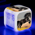 Small square cartoon-style LED alarm clock showing time and temperature, in one of 15 available colour variants.