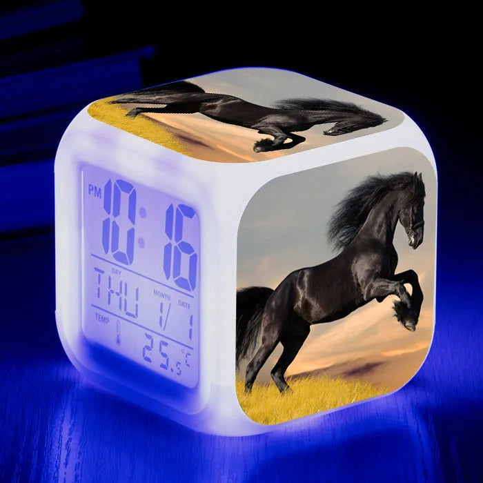 Small square cartoon-style LED alarm clock showing time and temperature, in one of 15 available colour variants.