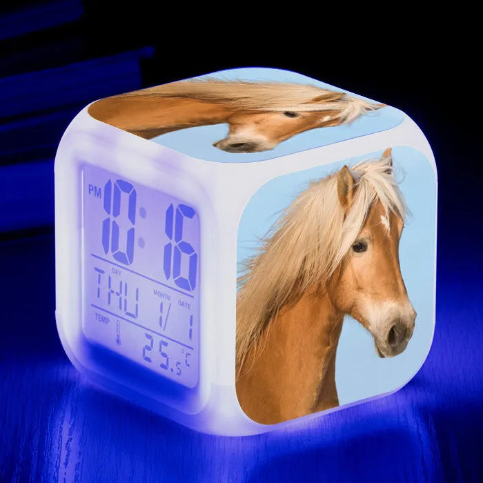 Small square cartoon-style LED alarm clock showing time and temperature, in one of 15 available colour variants.