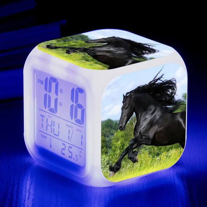Small square cartoon-style LED alarm clock showing time and temperature, in one of 15 available colour variants.
