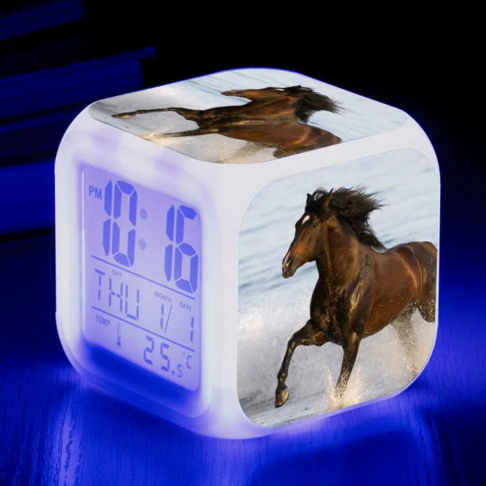 Small square cartoon-style LED alarm clock showing time and temperature, in one of 15 available colour variants.