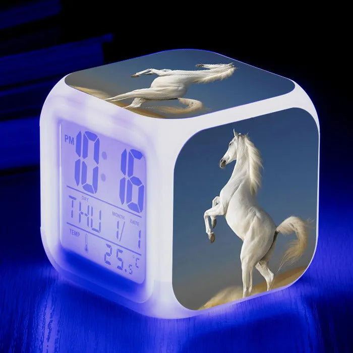 Small square cartoon-style LED alarm clock showing time and temperature, in one of 15 available colour variants.