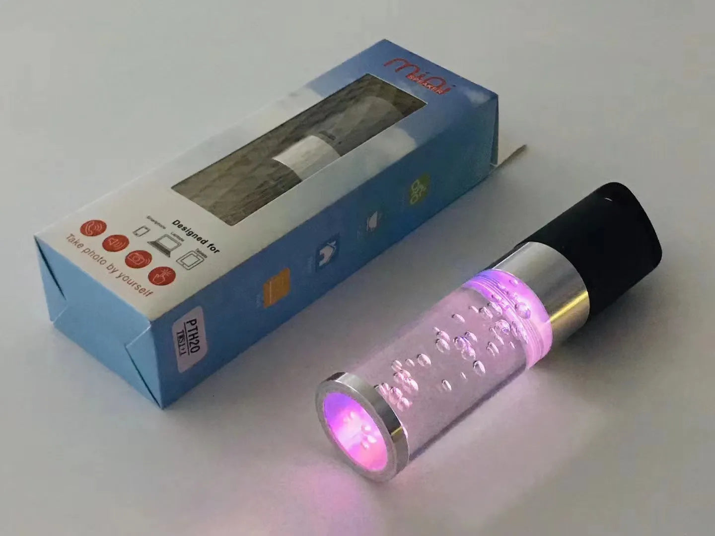 Pink portable Bluetooth speaker with colourful cartoon crystal LED lights on display.