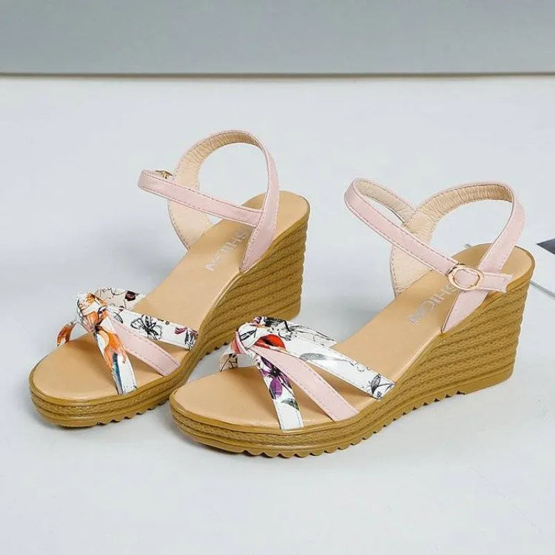 Women's pink wedge sandals with a thick heel, fish mouth toe, and a silver buckle closure on a waterproof platform sole.