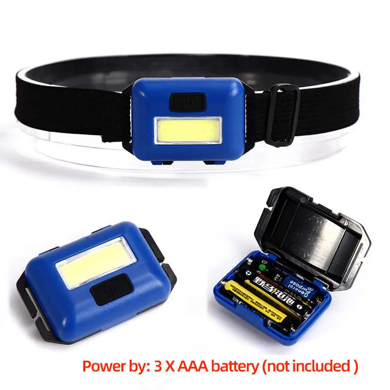 Compact black, blue, or red outdoor LED headlamp with adjustable strap on a grey background