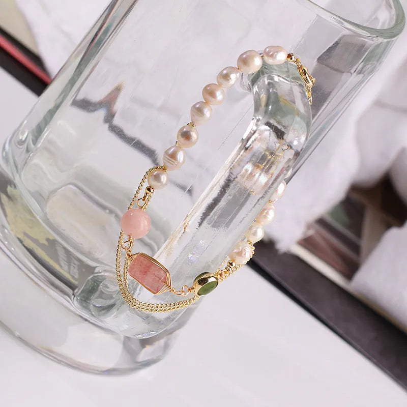 Pink women's bracelet with freshwater pearls and a geometric strawberry crystal charm, model UG309.