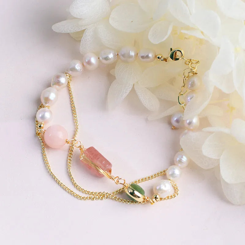 Pink women's bracelet with freshwater pearls and a geometric strawberry crystal charm, model UG309.