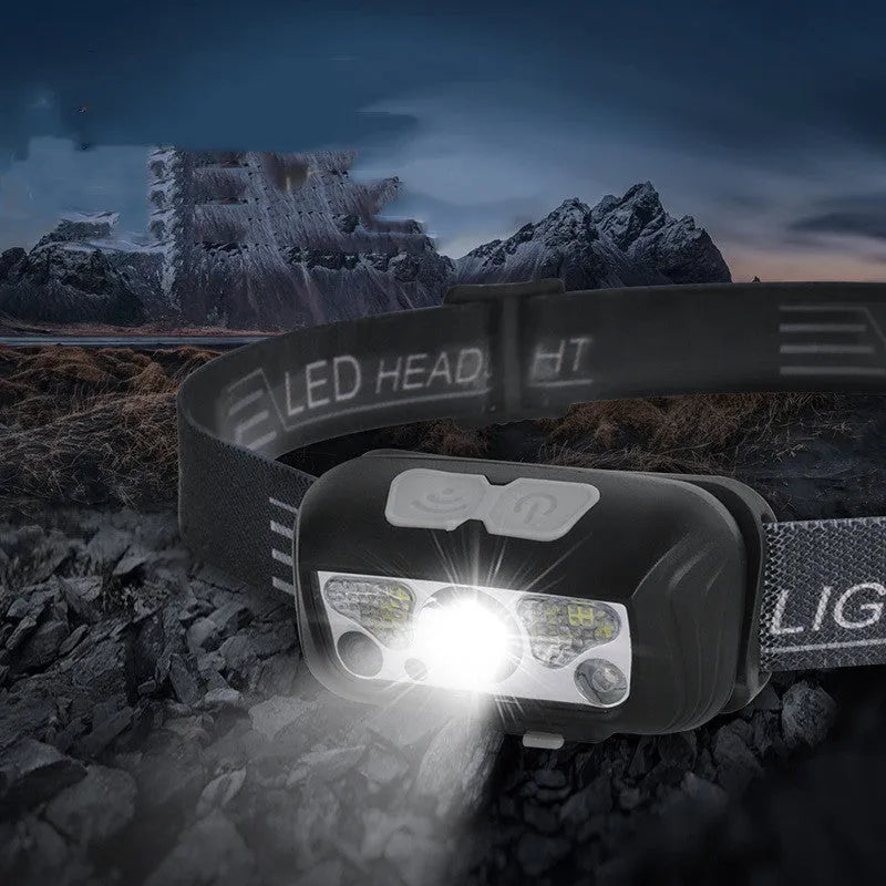 Black USB-rechargeable sensor headlight showing white front LED and dual red rear safety lights.