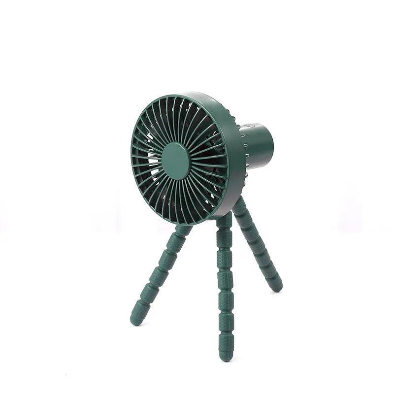 Black flexible tripod USB desktop fan with automatic head shake, shown on a desk next to a laptop.