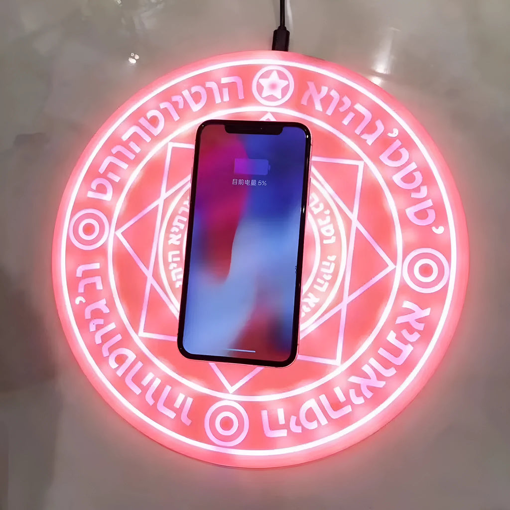 Black 10W fast wireless phone charger with glowing magic array pattern on a desk.