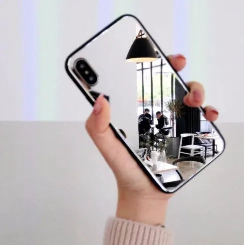 Black iPhone mirror phone case showing reflective glass back, compatible with multiple iPhone models.