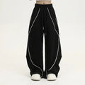 Black and white striped wide-leg hip hop sports trousers with pleats, shown laid flat.